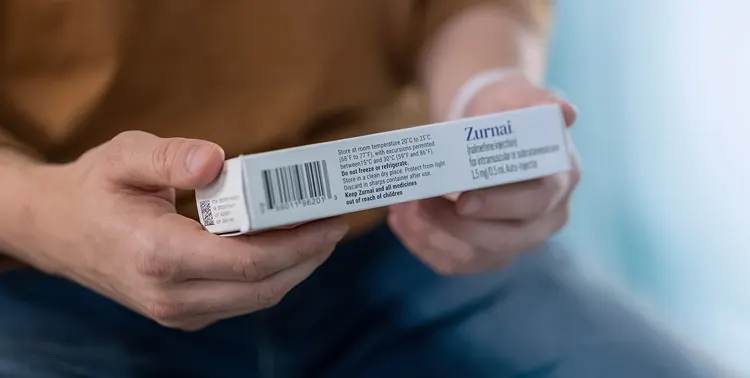 A man's hands holding the carton containing ZURNAI